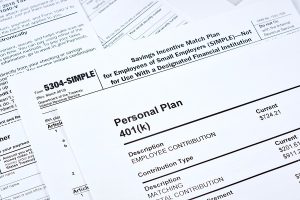 Close-up of 401(k) and SIMPLE IRA retirement plan documents for employee contributions.