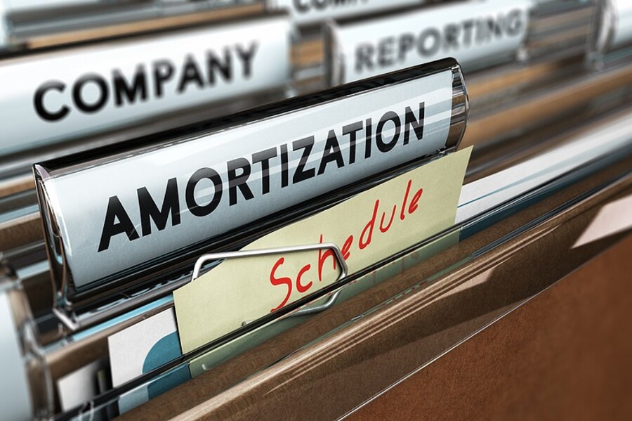 Close-up of file folders labeled "Amortization" and "Schedule" in an office filing system.