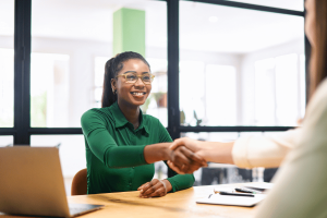 Hiring manager shaking hands with job candidate during interview